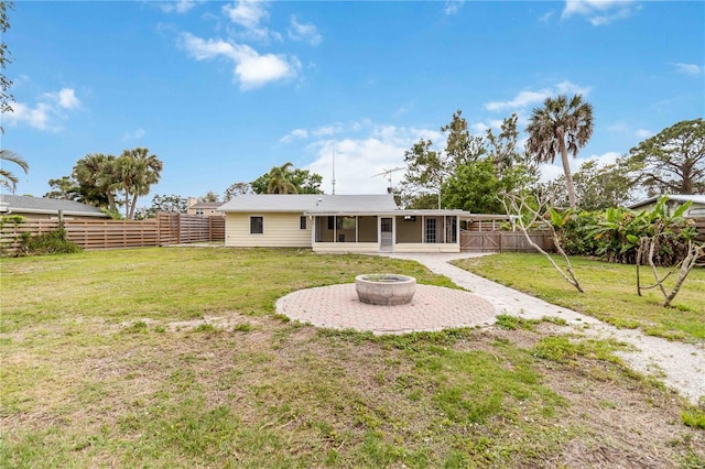 217 Palm Ave E, Nokomis, FL 34275 - back of property featuring a sunroom, a fire pit, and a patio area