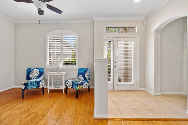 unfurnished room featuring ornamental molding, tile patterned floors, a ceiling fan, and arched walkways