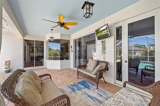sunroom featuring a wealth of natural light, an outdoor living space, and a ceiling fan