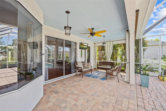 sunroom / solarium featuring ceiling fan, a wealth of natural light, and an outdoor living space