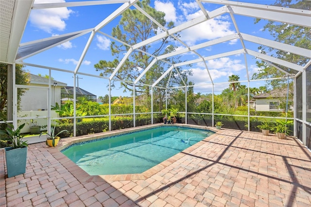 outdoor pool with a patio area and glass enclosure