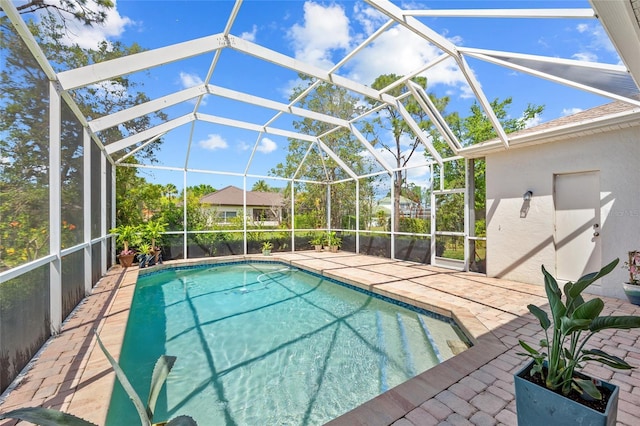 outdoor pool featuring a patio and glass enclosure
