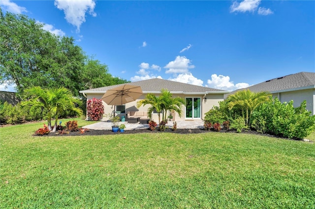 back of property with stucco siding, outdoor lounge area, a yard, and a patio area