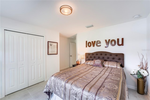 bedroom with a closet, baseboards, visible vents, and light tile patterned floors