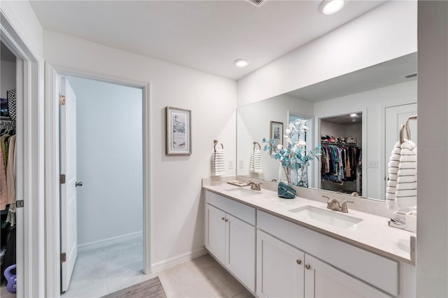 bathroom featuring double vanity, a sink, baseboards, and recessed lighting