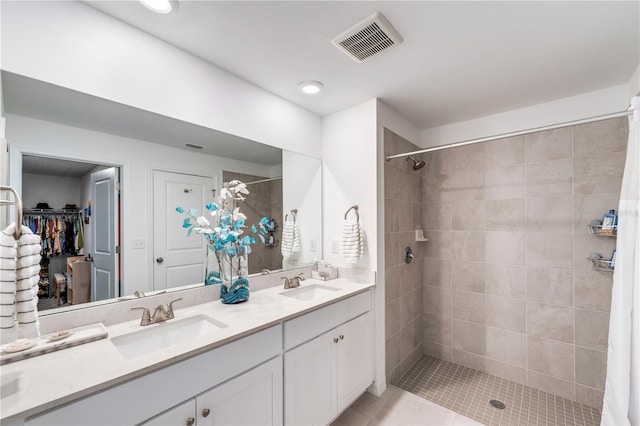 bathroom with a sink, double vanity, visible vents, and a stall shower
