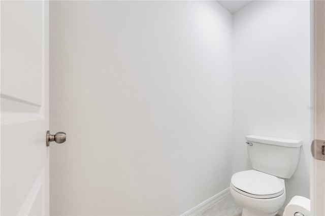 bathroom featuring baseboards, toilet, and tile patterned flooring