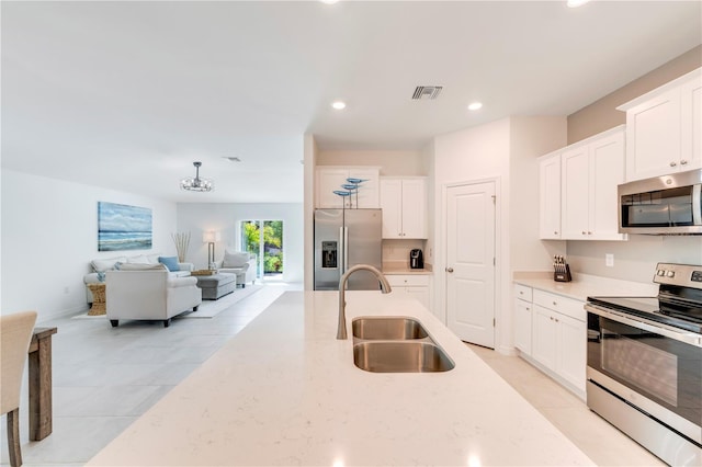 kitchen featuring visible vents, white cabinets, a sink, and appliances with stainless steel finishes
