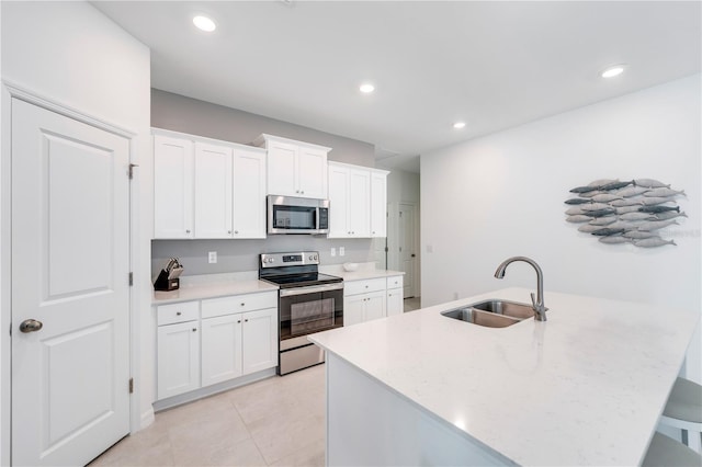 kitchen featuring white cabinetry, recessed lighting, a sink, an island with sink, and appliances with stainless steel finishes