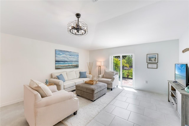 living area with baseboards, a notable chandelier, and light tile patterned floors