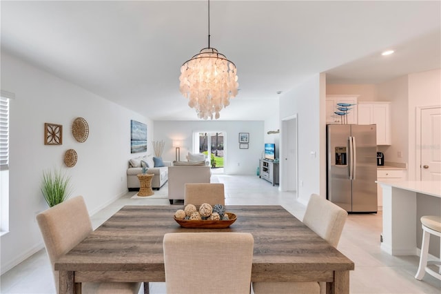 dining area with baseboards, a chandelier, and light tile patterned floors