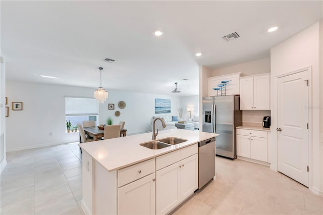 kitchen with open floor plan, a sink, appliances with stainless steel finishes, and visible vents