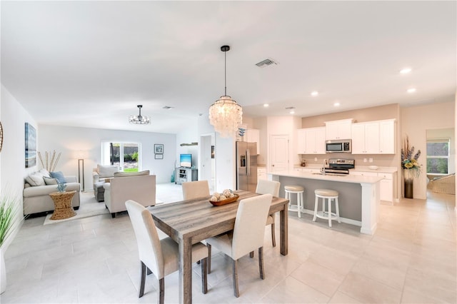 dining room featuring light tile patterned flooring, visible vents, recessed lighting, and a notable chandelier