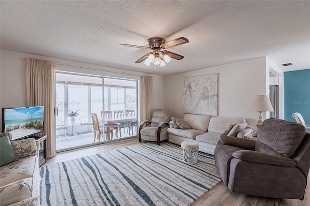 3249 Sunrise Trl, Port Charlotte, FL 33952 - living area featuring a ceiling fan, visible vents, a textured ceiling, and wood finished floors