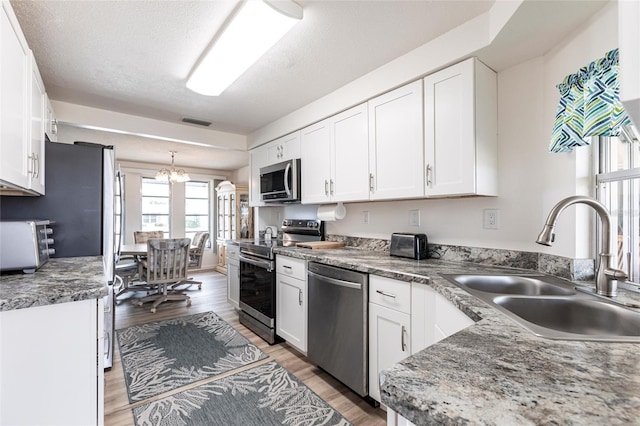 3249 Sunrise Trl, Port Charlotte, FL 33952 - kitchen featuring light wood-type flooring, a sink, visible vents, white cabinets, and appliances with stainless steel finishes