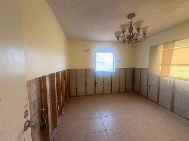 134 Peace Island Dr, Punta Gorda, FL 33950 - spare room featuring wainscoting, a notable chandelier, and a textured ceiling