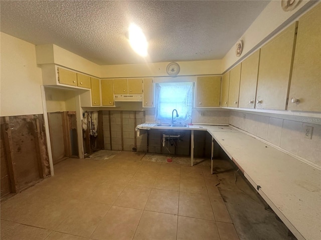 134 Peace Island Dr, Punta Gorda, FL 33950 - kitchen featuring a textured ceiling, light countertops, under cabinet range hood, a sink, and light tile patterned floors