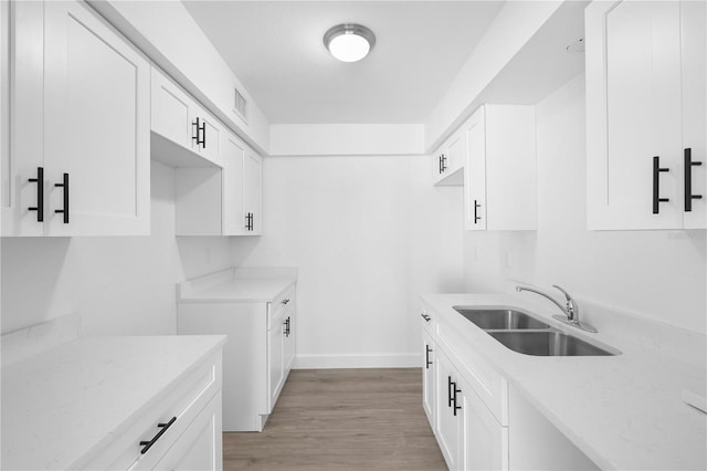 6500 Estero Blvd Unit F116, Fort Myers Beach, FL 33931 - kitchen with light wood-type flooring, white cabinets, and light stone counters