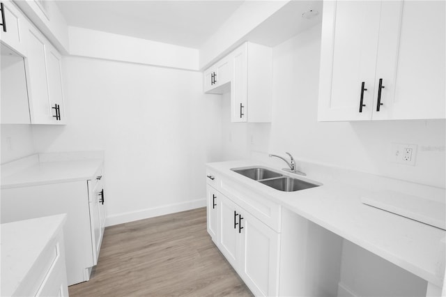 6500 Estero Blvd Unit F116, Fort Myers Beach, FL 33931 - kitchen featuring light countertops, white cabinetry, and light wood-style flooring