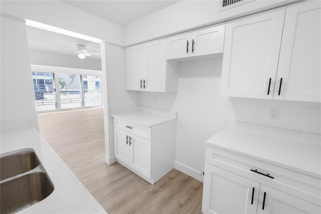 6500 Estero Blvd Unit F116, Fort Myers Beach, FL 33931 - kitchen featuring light countertops, light wood-type flooring, ceiling fan, and white cabinets