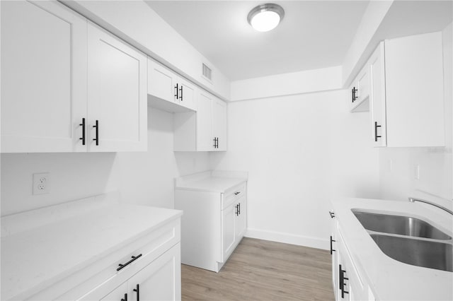 6500 Estero Blvd Unit F116, Fort Myers Beach, FL 33931 - kitchen featuring light countertops, white cabinets, and light wood-style floors