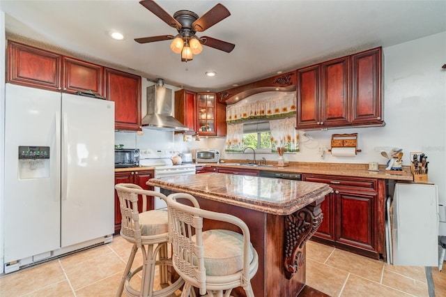 402 Cicero St NW, Port Charlotte, FL 33948 - kitchen with light tile patterned floors, wall chimney range hood, white appliances, ceiling fan, and dark brown cabinets