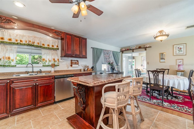 402 Cicero St NW, Port Charlotte, FL 33948 - kitchen with dishwasher, ceiling fan, a kitchen island, reddish brown cabinets, and a sink