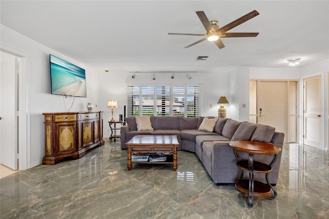 living area featuring marble finish floor, visible vents, ceiling fan, and a textured ceiling