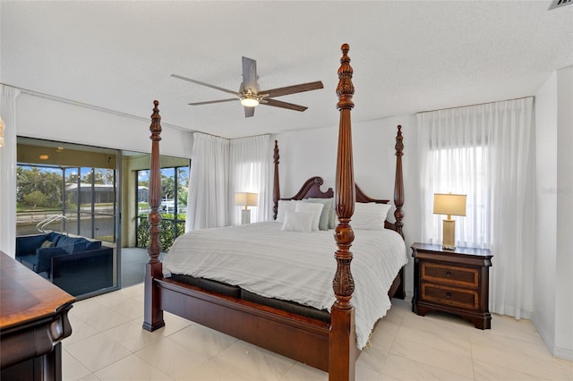 bedroom with multiple windows, access to outside, and a textured ceiling