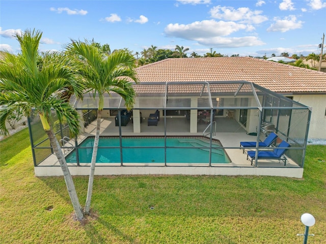 pool featuring a lanai, a patio area, and a yard