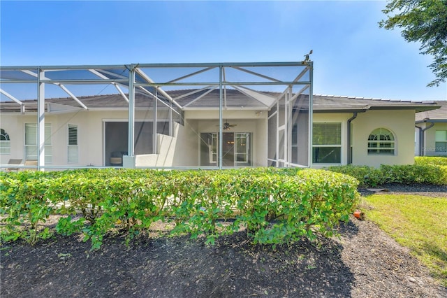 11291 Wine Palm Rd, Fort Myers, FL 33966 - rear view of house featuring glass enclosure, stucco siding, and ceiling fan