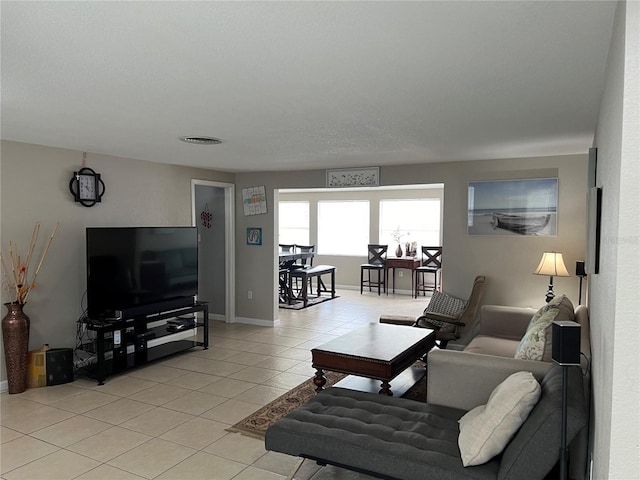 living room featuring baseboards and light tile patterned floors