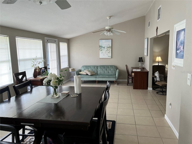 dining area featuring light tile patterned floors, visible vents, lofted ceiling, and ceiling fan