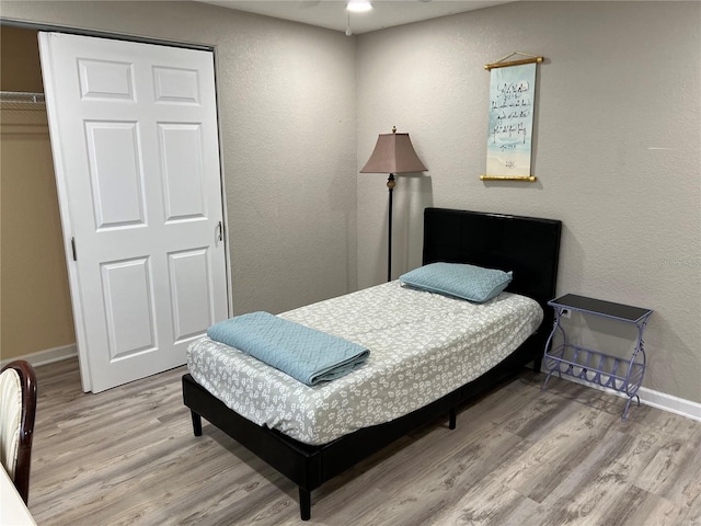 bedroom with baseboards and wood finished floors