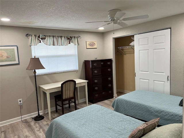 bedroom featuring a closet, a textured ceiling, baseboards, and light wood finished floors