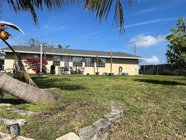 back of property featuring stucco siding, fence, a patio, and a yard