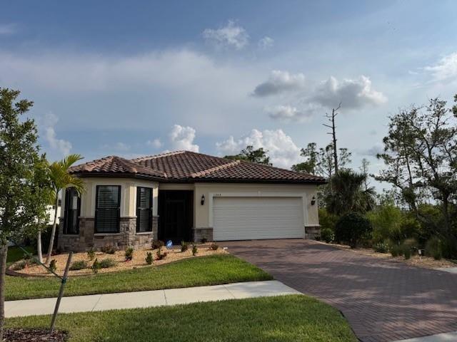 1263 Cicely Ct, North Port, FL 34289 - mediterranean / spanish house with decorative driveway, a tile roof, a garage, and stucco siding