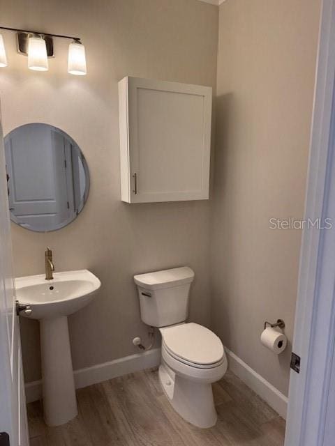 1263 Cicely Ct, North Port, FL 34289 - bathroom featuring toilet, baseboards, wood finished floors, and a sink
