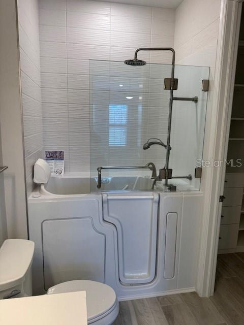 1263 Cicely Ct, North Port, FL 34289 - bathroom with a shower, a bath, wood finished floors, and toilet