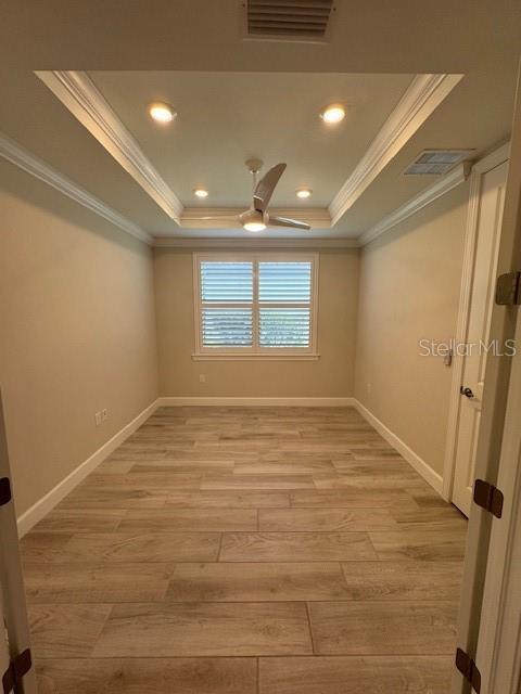 1263 Cicely Ct, North Port, FL 34289 - empty room featuring crown molding, a tray ceiling, ceiling fan, light wood finished floors, and baseboards