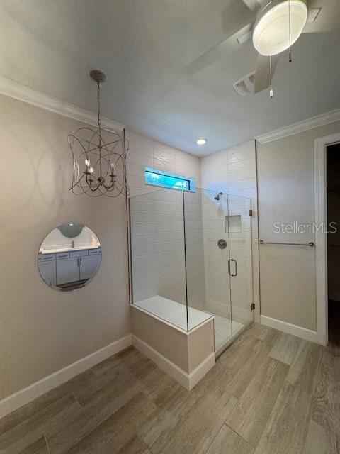 1263 Cicely Ct, North Port, FL 34289 - full bath with wood finished floors, crown molding, a stall shower, ceiling fan, and baseboards