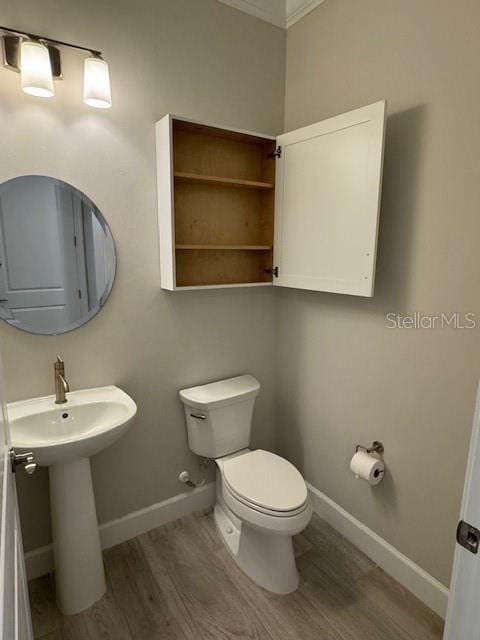 1263 Cicely Ct, North Port, FL 34289 - half bathroom featuring wood finished floors, toilet, baseboards, and ornamental molding
