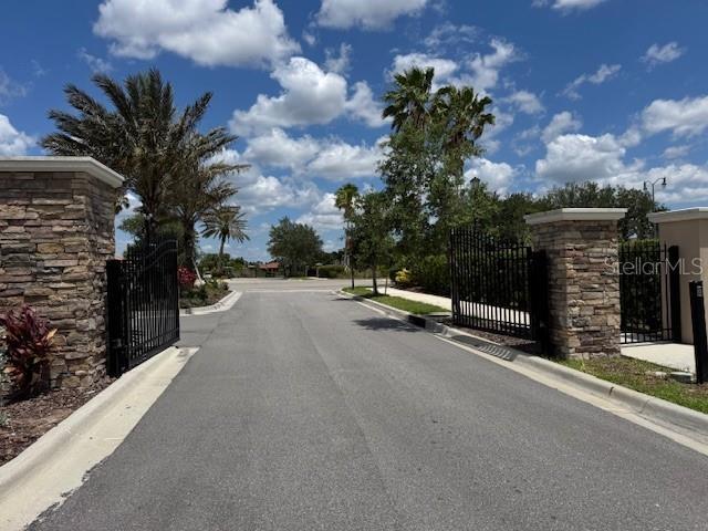 1263 Cicely Ct, North Port, FL 34289 - view of asphalt street featuring curbs, a gate, and a gated entry