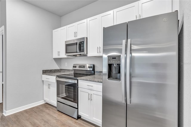 20241 Lorette Ave, Port Charlotte, FL 33954 - kitchen featuring baseboards, appliances with stainless steel finishes, white cabinetry, light wood-style flooring, and stone countertops
