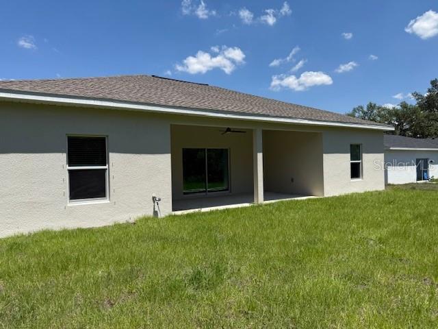 20241 Lorette Ave, Port Charlotte, FL 33954 - back of property with a yard, a patio, stucco siding, and ceiling fan