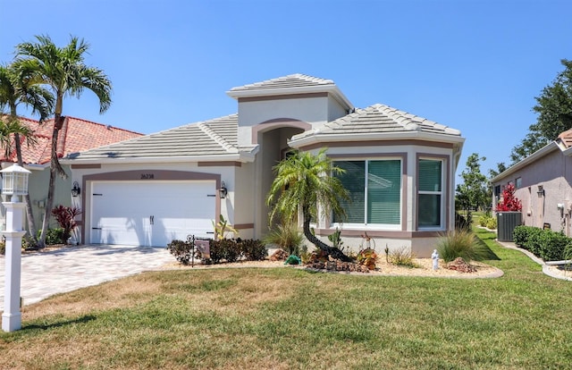 view of front of property with a garage, a tile roof, a front yard, and stucco siding