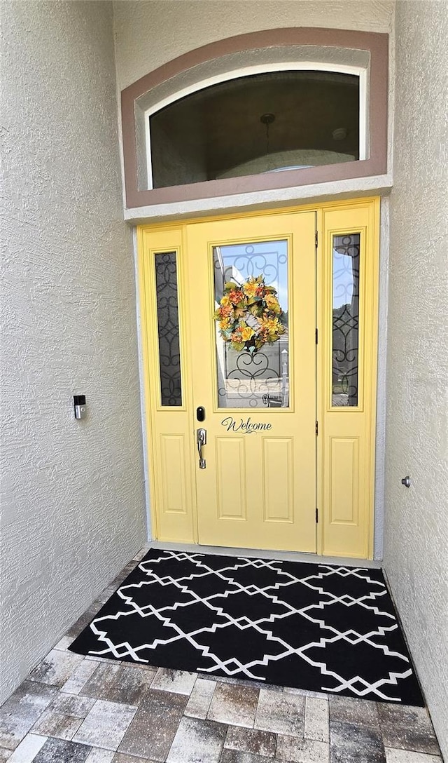 view of exterior entry featuring stucco siding