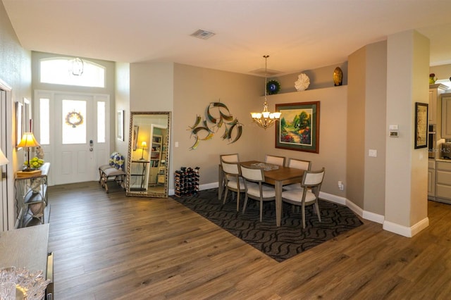 dining area featuring baseboards, a notable chandelier, wood finished floors, and visible vents