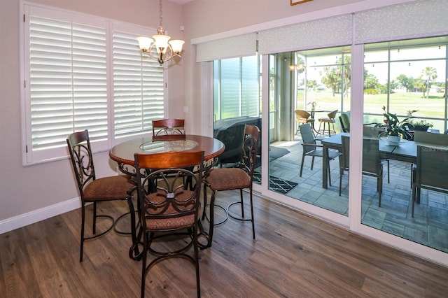 dining area with baseboards, wood finished floors, a chandelier, and a healthy amount of sunlight