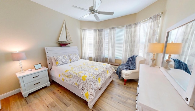 bedroom with baseboards, a ceiling fan, and light wood-style floors